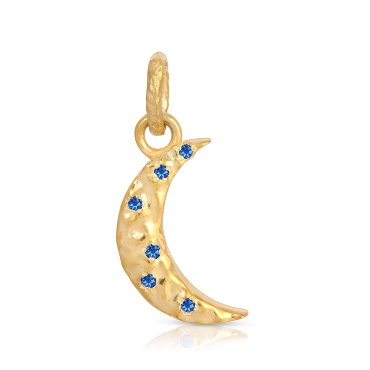 A gold crescent moon charm decorated with small blue gemstones, shown on a clean white background with a subtle reflection.